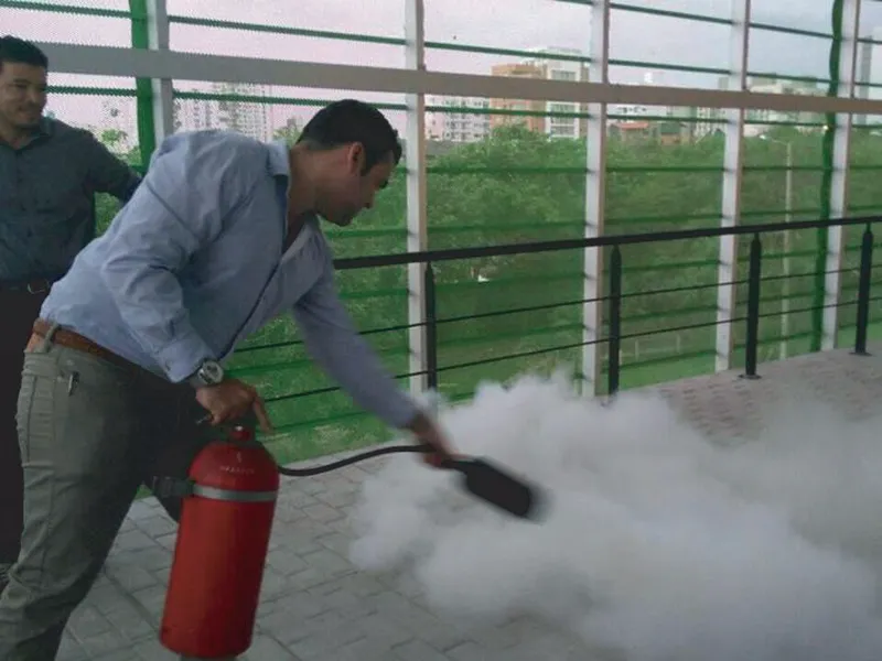Instructor de Servindustrial descargando un extintor durante una capacitación