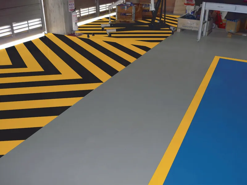 Piso industrial demarcado con franjas amarillas y negras
